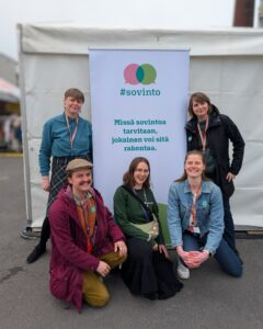 Viisi nuorta aikuista poseeraa #sovinto-teeman taustalla, jossa on teksti "Missä sovintoa tarvitaan, jokainen voi sitä rakentaa.